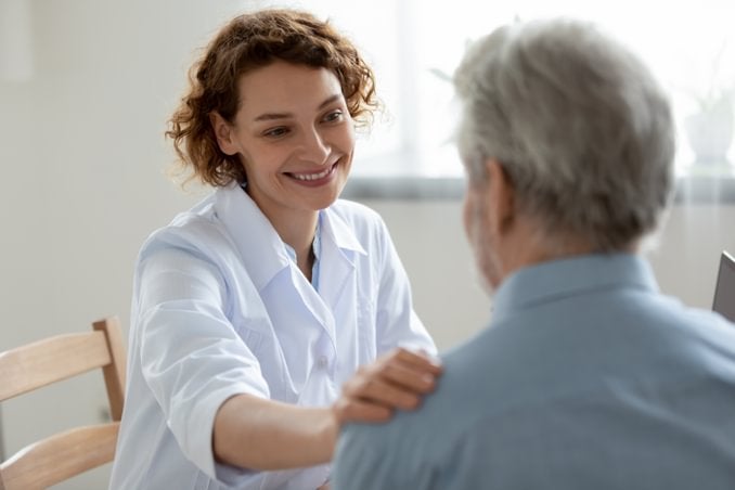 female mental health social worker talking with an elderly male patient